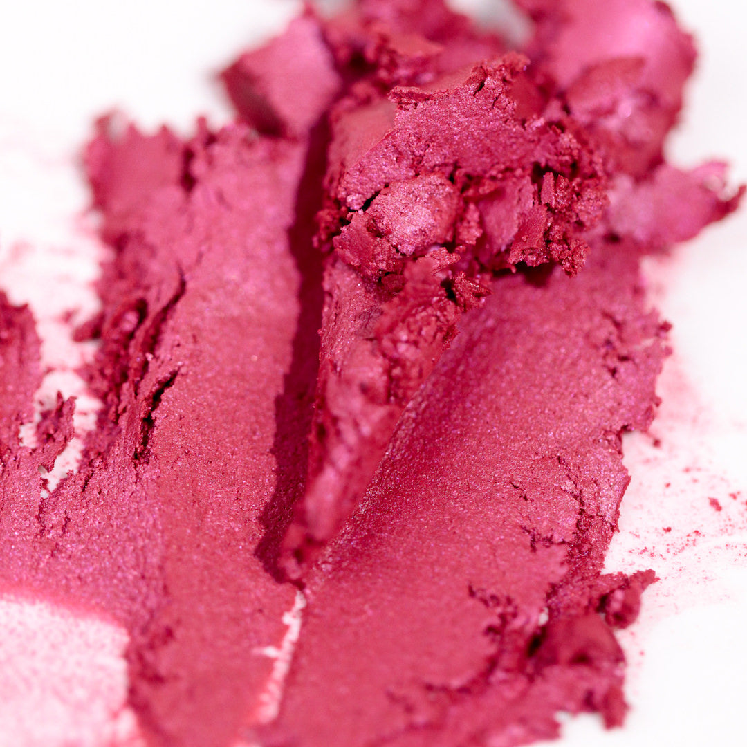 Close-up of smushed pink lipstick on a white background