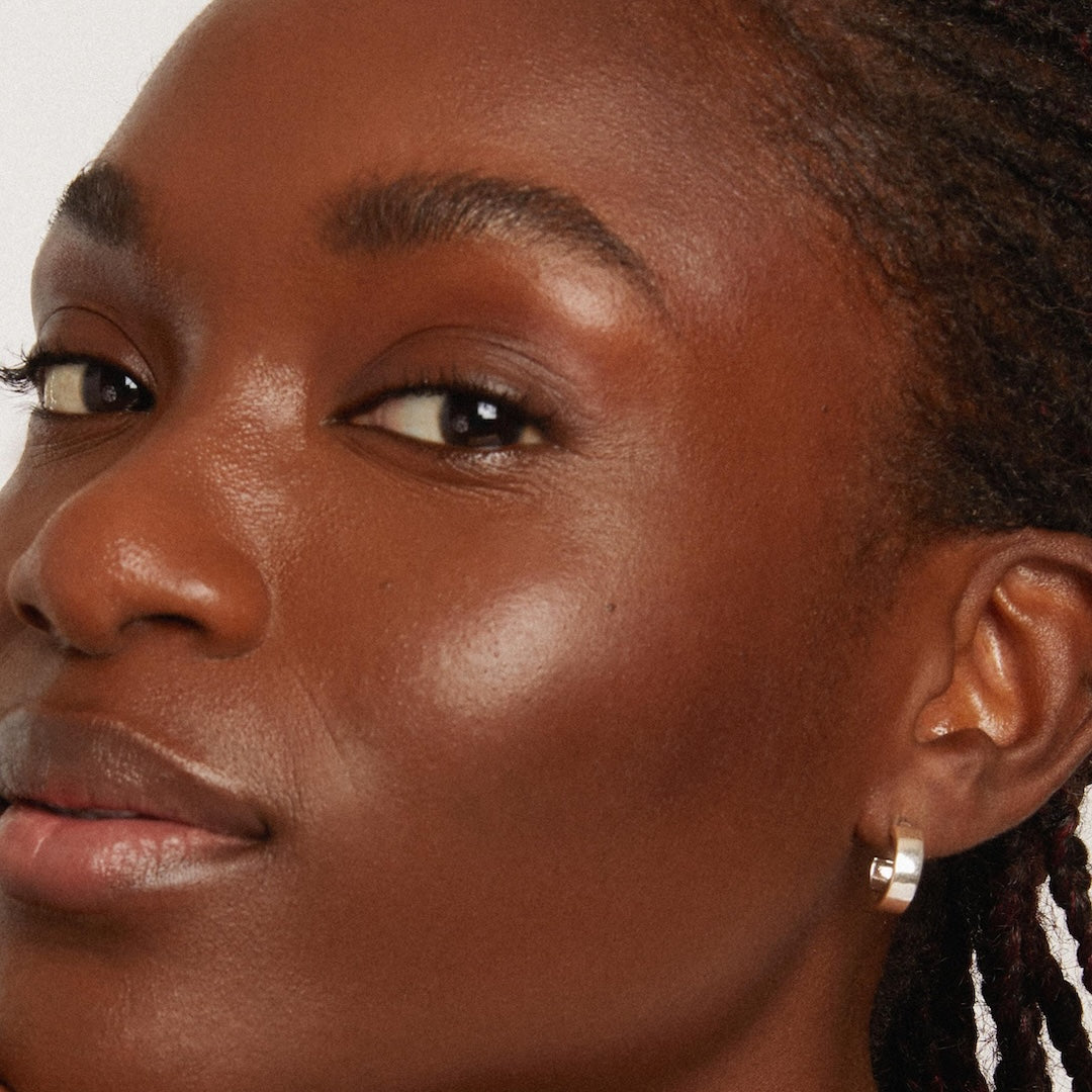 Close-up of a woman's face with a neutral expression, focusing on her cheek