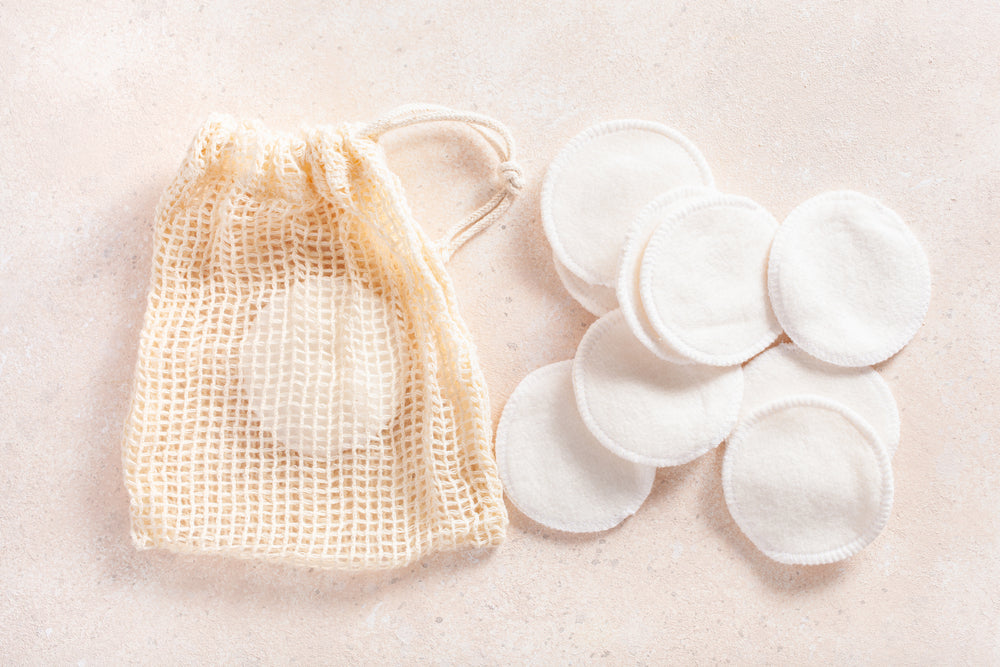 Mesh bag and reusable cotton pads on a light beige background